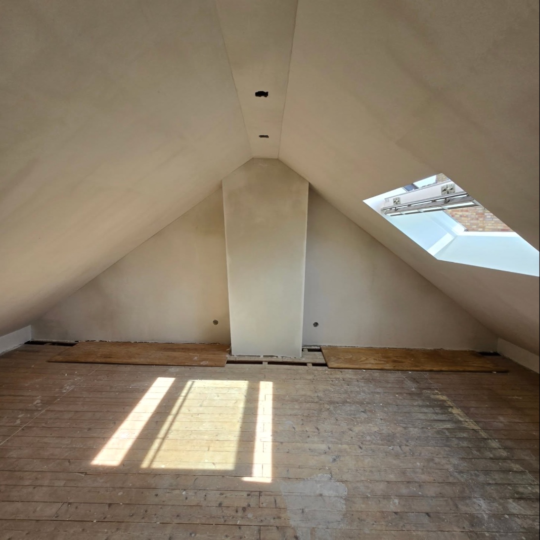 Attic with a roof window and smoothly plastered sloping ceilings
