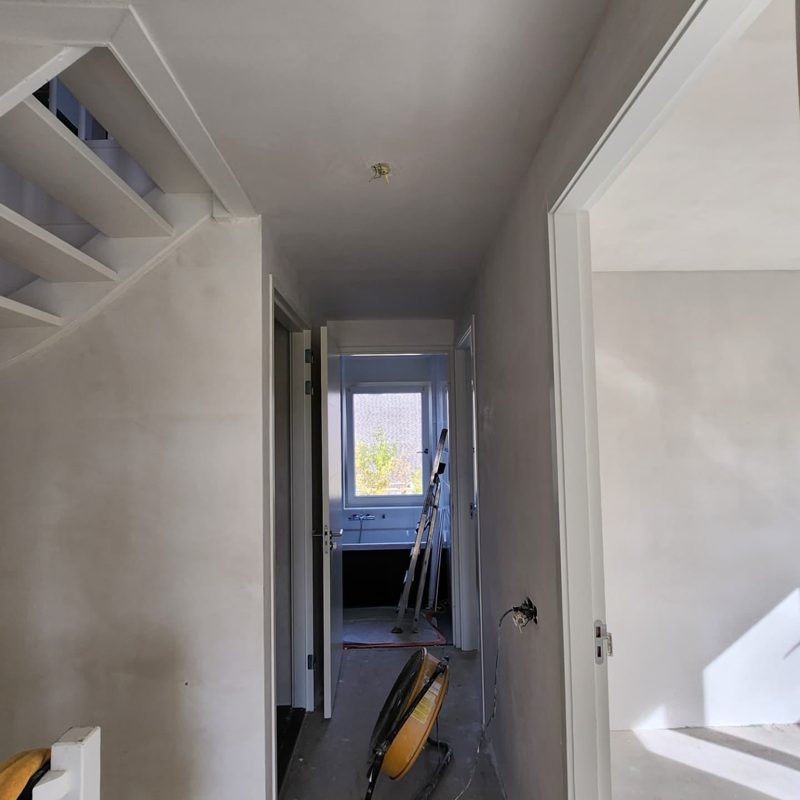 Na: dezelfde overloop met glad gestucte wanden en plafond
